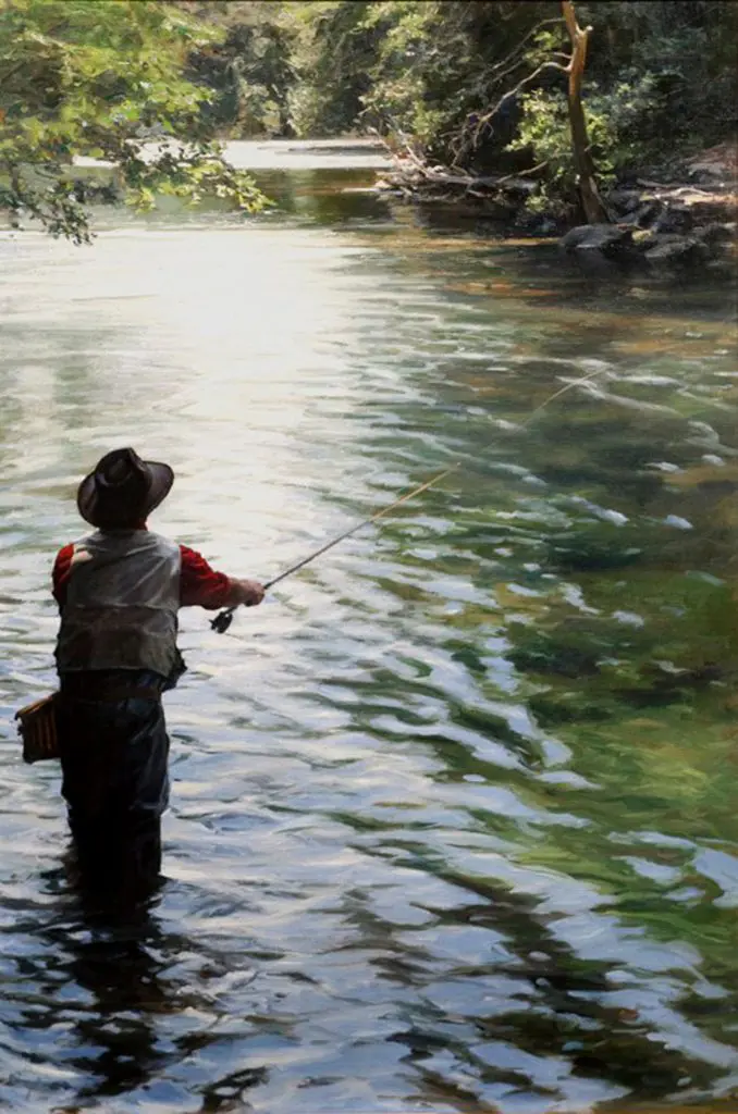 Man standing in a river on a sunny day, casting out his line