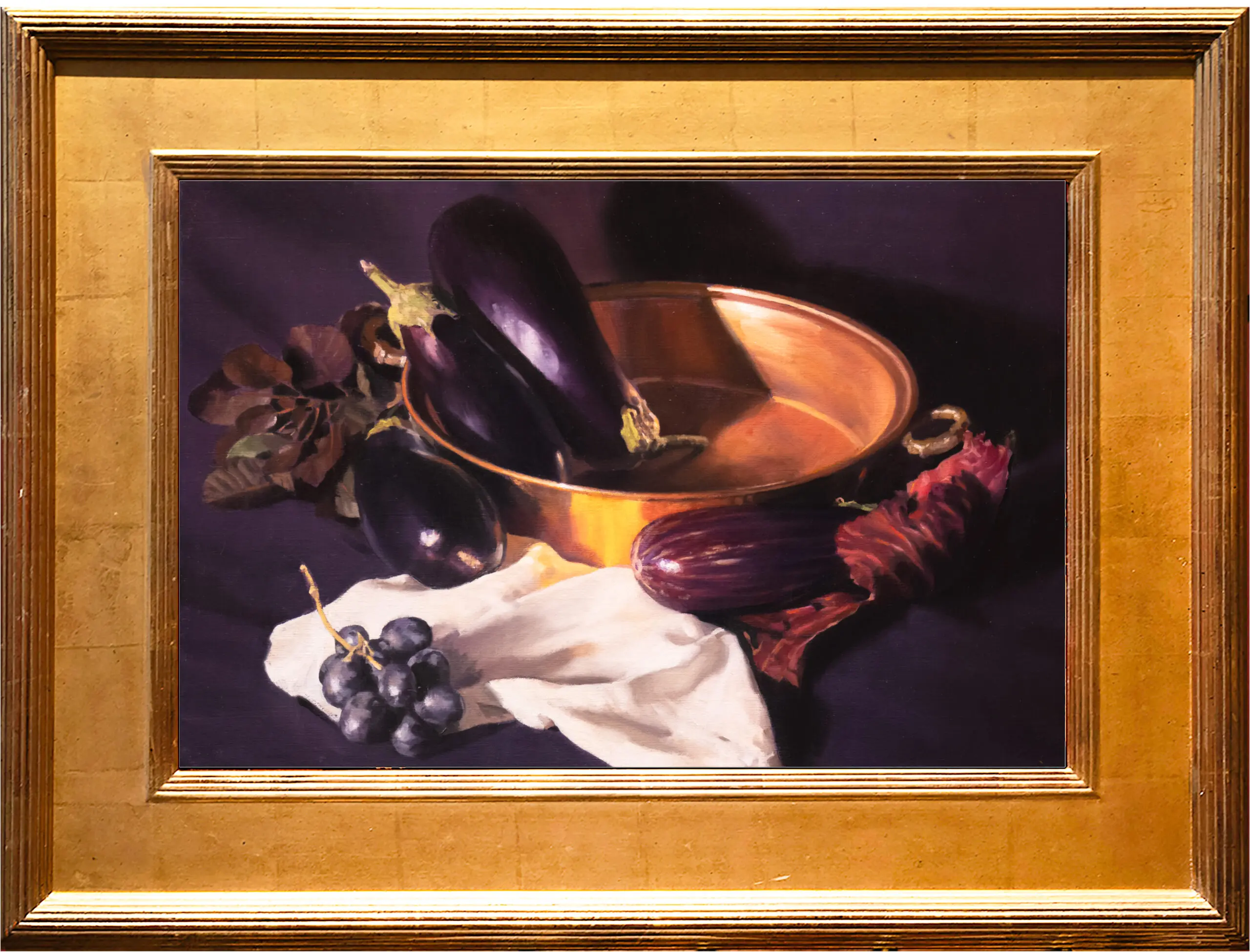 Eggplants sitting in a gold bowl in front of a purple background