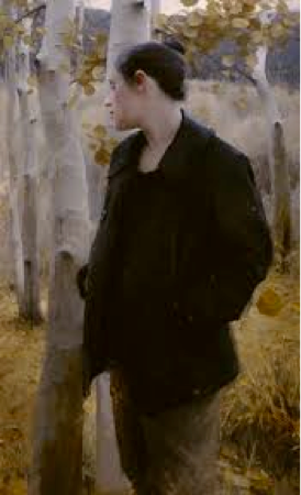 Man wearing dark clothes standing in a birch tree forest