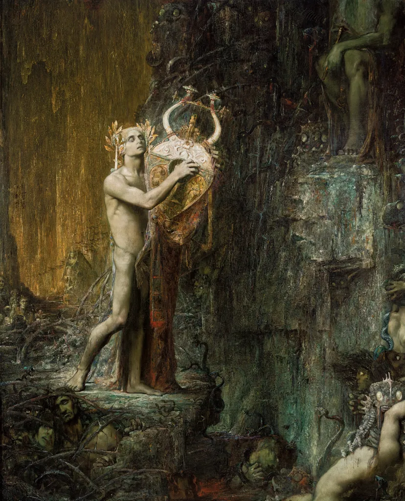 Nude man holding a large gold instrument standing alongside a rocky landscape