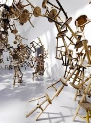 Numerous wooden stools in a wave formation in a white room