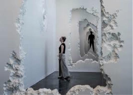 Woman and man standing in a white gallery with wholes in the walls